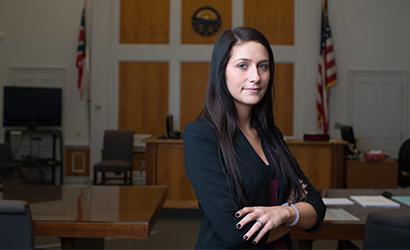 Student poses in a courtroom