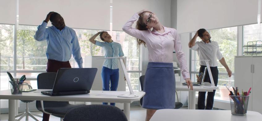 Group of people stretching at their desks
