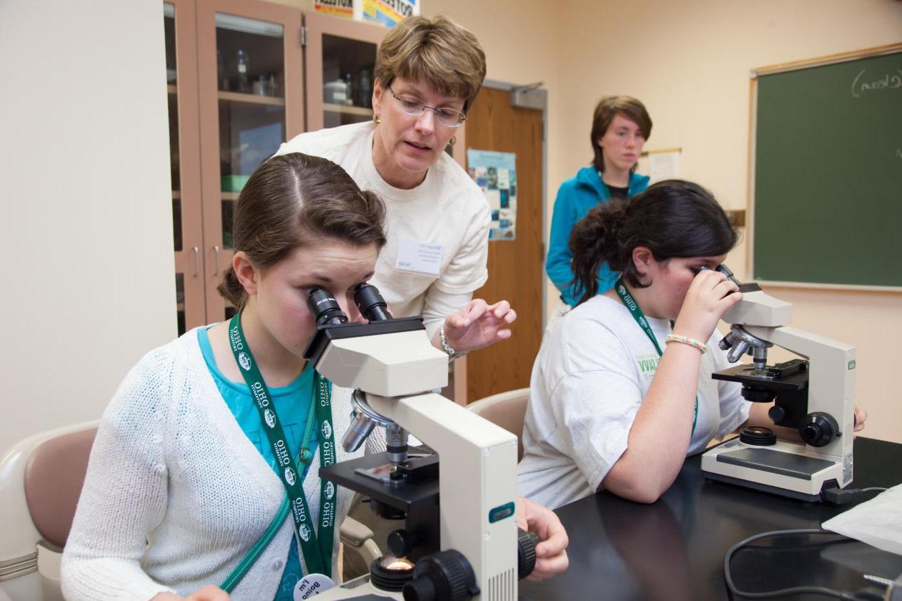 精通技术的参与者在实验室里观察显微镜